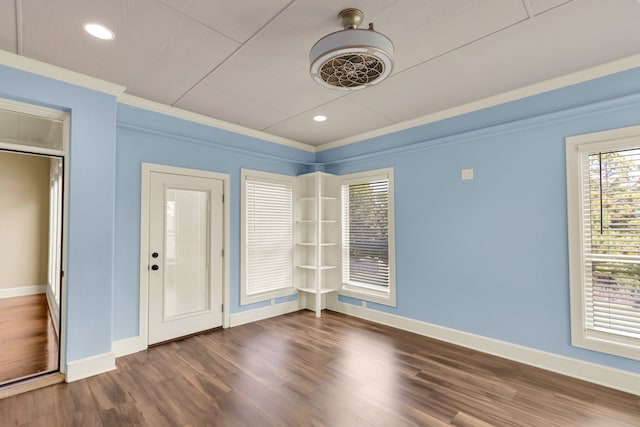 empty room featuring ornamental molding and dark wood-type flooring