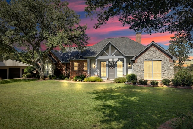 view of front facade with a yard, an outdoor structure, and a garage