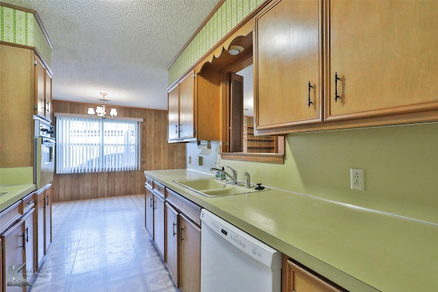 kitchen featuring pendant lighting, dishwasher, sink, a textured ceiling, and a chandelier