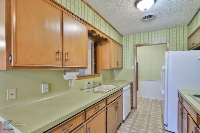 kitchen featuring a textured ceiling, white appliances, and sink