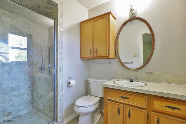 bathroom featuring vanity, toilet, a textured ceiling, and walk in shower