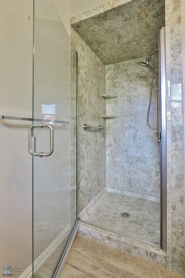 bathroom featuring a shower with door