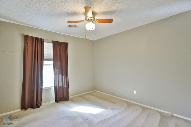 unfurnished room with a textured ceiling, ceiling fan, and light carpet