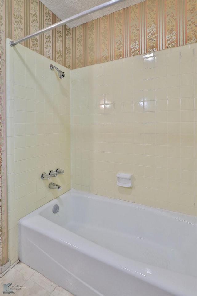 bathroom with tile patterned flooring and tiled shower / bath