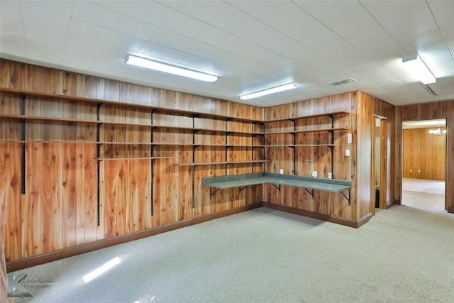 basement featuring light carpet and wooden walls