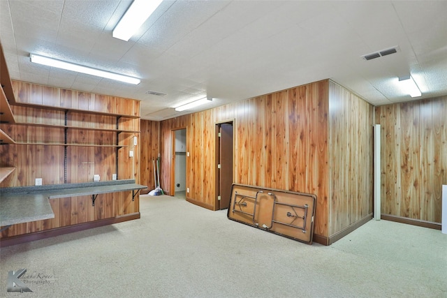 interior space with light colored carpet and wood walls