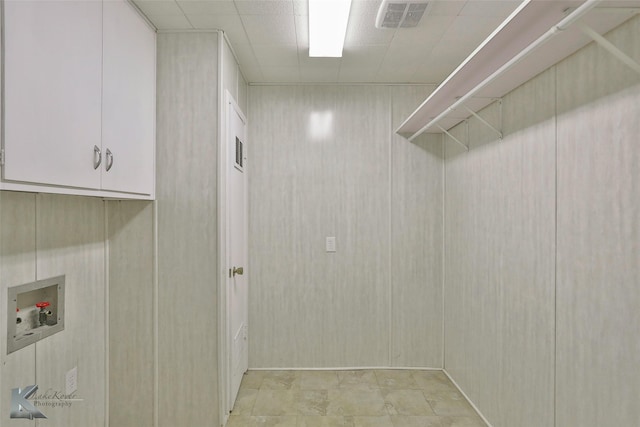 washroom featuring hookup for a washing machine and cabinets