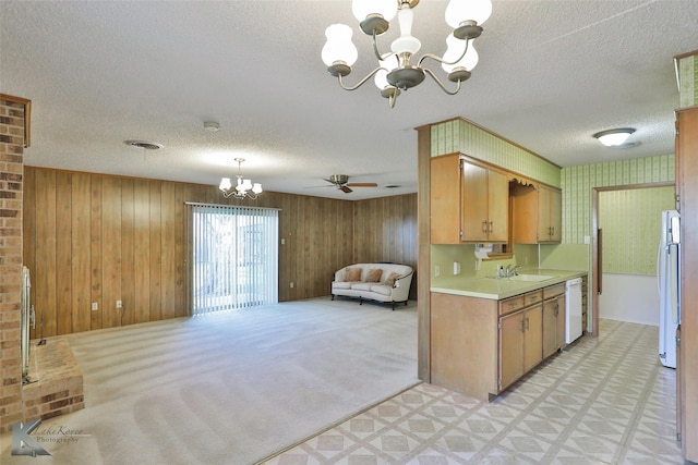 kitchen with a textured ceiling, ceiling fan with notable chandelier, white appliances, and sink