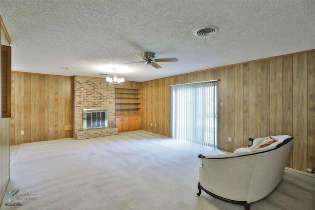 sitting room with a fireplace, a textured ceiling, carpet floors, and wood walls