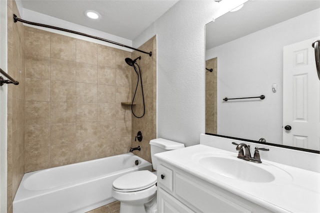 full bathroom featuring tiled shower / bath, vanity, toilet, and tile patterned flooring