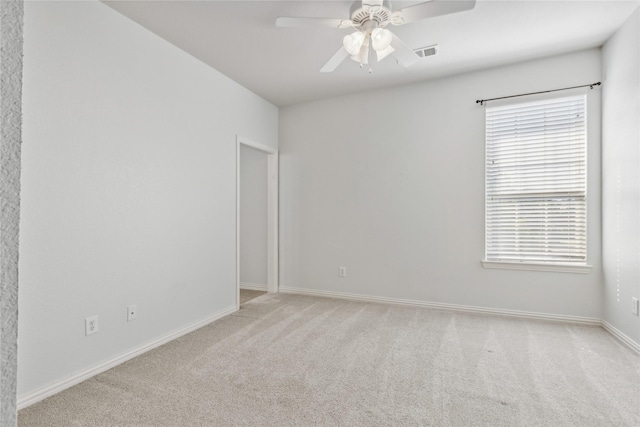 unfurnished room with light colored carpet and ceiling fan