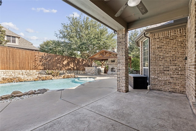 view of pool with exterior fireplace, a gazebo, a patio, and ceiling fan