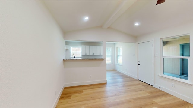 foyer entrance with vaulted ceiling with beams and light hardwood / wood-style floors