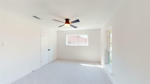 carpeted spare room with ceiling fan