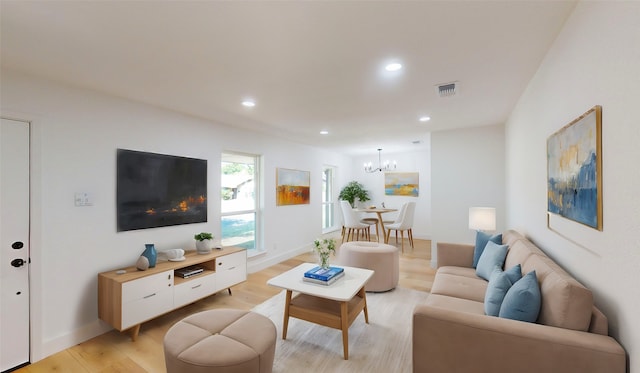 living room featuring a notable chandelier and light wood-type flooring