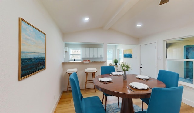 dining room featuring lofted ceiling with beams and light wood-type flooring