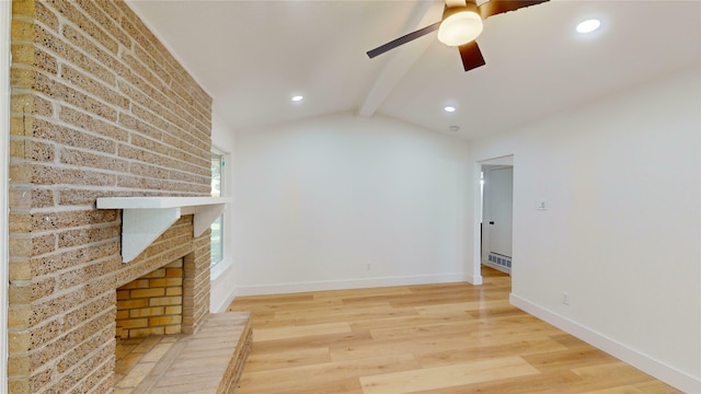 unfurnished living room with a brick fireplace, lofted ceiling with beams, hardwood / wood-style floors, and ceiling fan