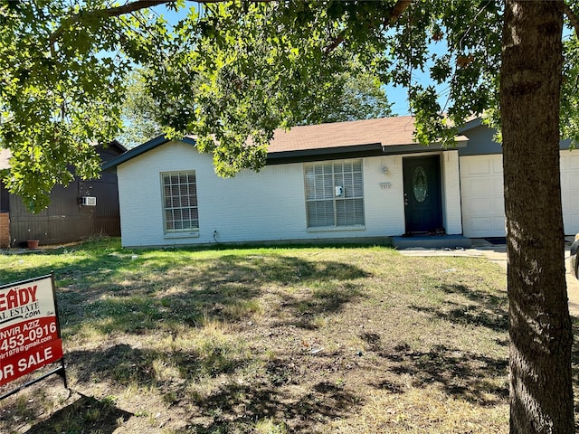 single story home featuring a garage and a front lawn