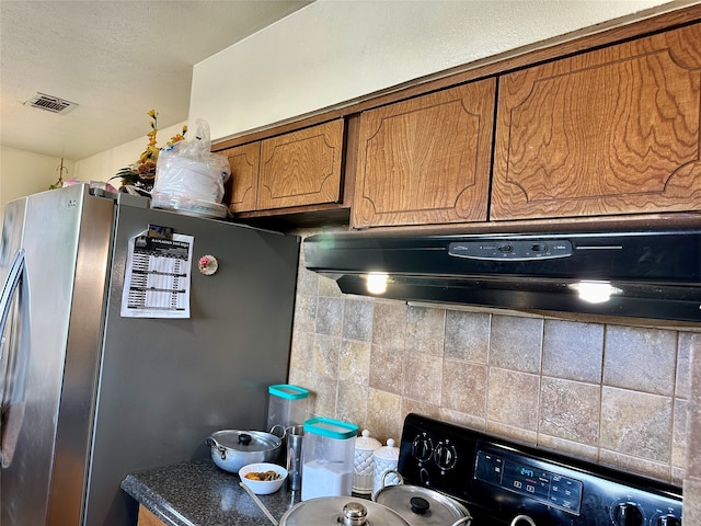 kitchen with stainless steel refrigerator, white range, backsplash, and range hood