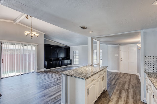 kitchen featuring light stone countertops, lofted ceiling with beams, dark hardwood / wood-style floors, a notable chandelier, and white cabinets