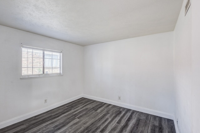 empty room featuring dark hardwood / wood-style flooring and a textured ceiling