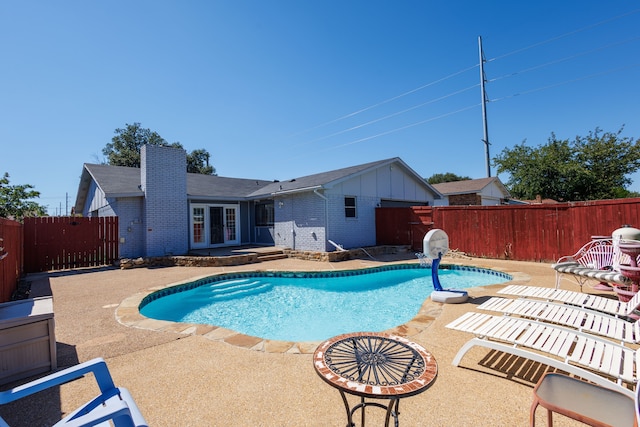 view of swimming pool with a patio and french doors