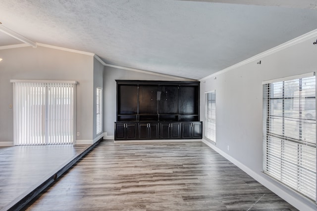 foyer with vaulted ceiling with beams, wood-type flooring, a textured ceiling, and ornamental molding