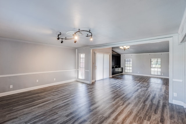 unfurnished living room with dark hardwood / wood-style flooring, an inviting chandelier, and ornamental molding