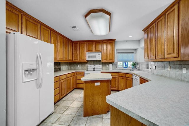 kitchen with a center island, white appliances, sink, light tile patterned floors, and tasteful backsplash