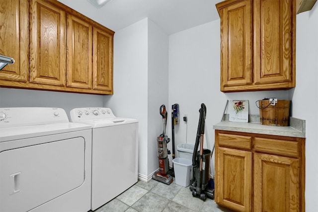 laundry room with separate washer and dryer, light tile patterned floors, and cabinets