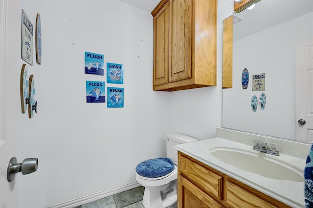 bathroom featuring tile patterned flooring, vanity, and toilet