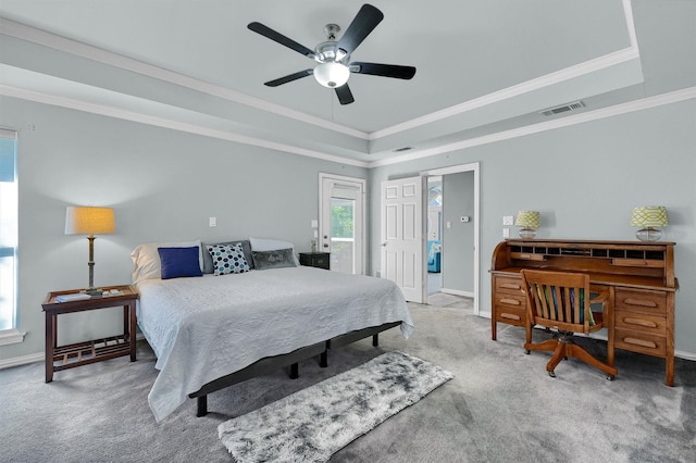 carpeted bedroom featuring ceiling fan, crown molding, and a tray ceiling