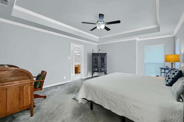 carpeted bedroom featuring ensuite bathroom, ceiling fan, ornamental molding, and a tray ceiling