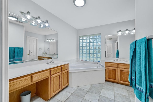 bathroom featuring tile patterned flooring, vanity, and a tub