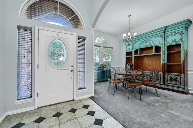 entrance foyer with light carpet, vaulted ceiling, and a notable chandelier