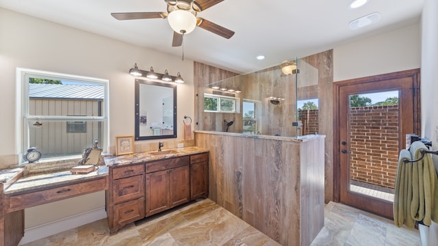 bathroom featuring vanity, a healthy amount of sunlight, and tiled shower