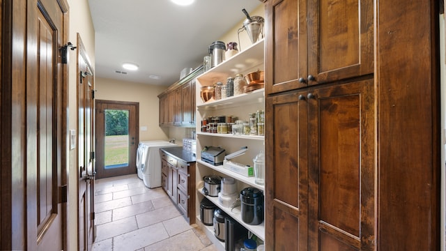 washroom with cabinets, independent washer and dryer, and light tile patterned floors