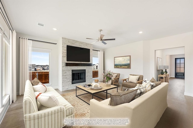 living room featuring a fireplace, light hardwood / wood-style flooring, and ceiling fan