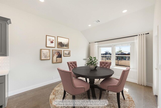 dining space featuring lofted ceiling and dark hardwood / wood-style floors