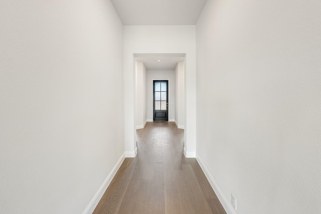 hallway with hardwood / wood-style floors