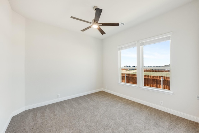 carpeted spare room featuring ceiling fan