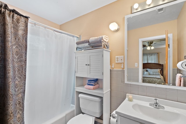 full bathroom featuring tile walls, vanity, shower / bath combination with curtain, ceiling fan, and toilet