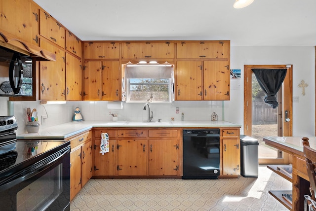 kitchen with black appliances, decorative backsplash, and sink