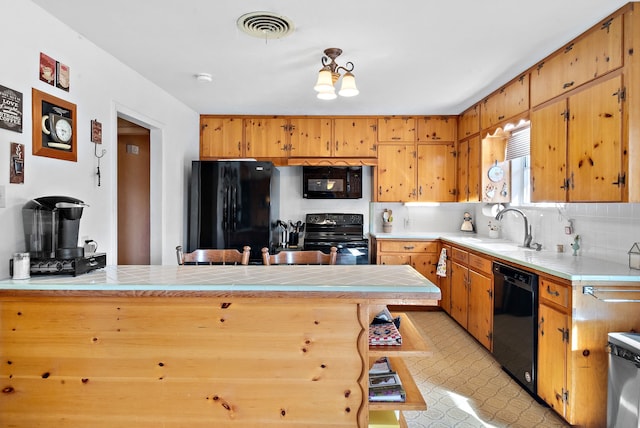 kitchen featuring sink, backsplash, kitchen peninsula, and black appliances