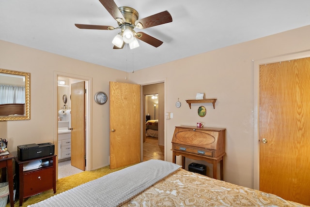 bedroom featuring ceiling fan, ensuite bath, and light carpet