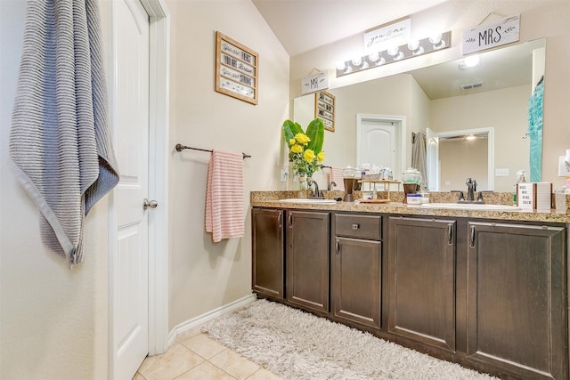 bathroom featuring vanity, lofted ceiling, and tile patterned flooring