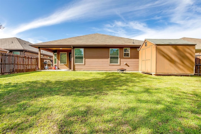 back of property with a storage shed, a lawn, and a patio area