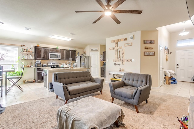 living room with ceiling fan, plenty of natural light, and light tile patterned floors