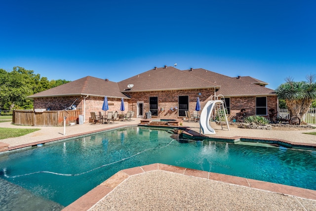 view of swimming pool featuring a water slide and a patio area