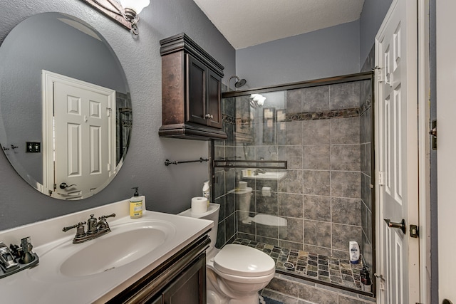 bathroom featuring walk in shower, vanity, toilet, and a textured ceiling